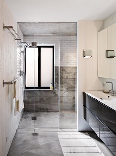 Bright Renovation of a 1970s Big Sur Home - Photo 8 of 10 - On the house’s lower level, Schicketanz’s guests have a bathroom complete with a steam shower to themselves. Anodized aluminum windows pop against white subway tile from Waterworks. The vanity is from Ikea and the fixtures from Hansgrohe.