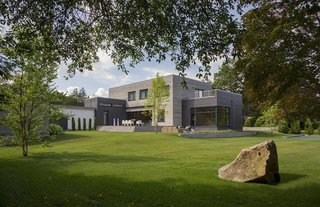 White stucco, shiplapped wood siding, and fiber cement panels adorn the exterior. The landscape architect was Soren deNiord.