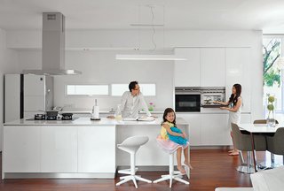 These 30 White Kitchens Are Anything But Ordinary - Photo 20 of 30 - For the kitchen, architect Ivan Priatman selected an oven, hood, and cooktop from Teka and a Samsung refrigerator. While the table is his own design, the bar stools and chairs are from Informa.