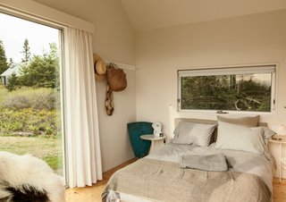 A Cluster of Cabins in a Former Quarry Makes a Simple Vacation Escape - Photo 11 of 13 - Situated between the main living space and the other bedroom, the middle cabin is furnished with a Calder side table by Konstantin Grcic, a vintage Dalu lamp by Vico Magistretti, and handwoven blankets from Swans Island Company.