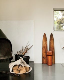 A Cluster of Cabins in a Former Quarry Makes a Simple Vacation Escape - Photo 10 of 13 - Antique accents and firewood bring warmth to the living area in the main cabin.