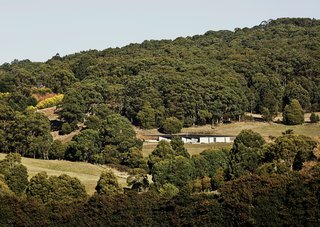 Architect Kerstin Thompson designed the low-slung structure to follow the sloping site. A steel roof and Thermomass precast concrete panels protect the house in the fire-prone bush.