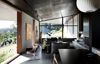 The interior shares the structure’s attention to texture and line. Furnishings include a pair of Arne Jacobsen’s AJ floor lamps and a Le Bambole sofa, armchairs, and ottoman by Mario Bellini for B&B Italia.