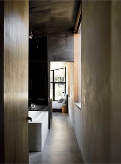 Dulux Ferrodor 810 industrial paint in Mid Grey, dark formply timber ceiling cladding, and concrete floors give the interiors a brooding intensity.