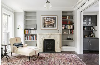 As much as the owners and Roberts wanted – and needed – to modernize the home, they also tried to honor some of its historical touches. They preserved the mantel, and replaced the plaster crowns on the parlor level. The antique chaise is by Lisa Sherman, and the walls are painted pavilion gray by Farrow & Ball.