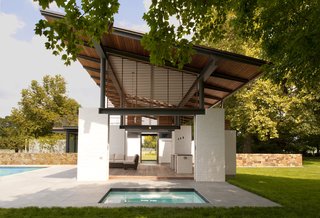 White-painted brick piers support the structure, which is designed to mimic design elements of the original 1930s farmhouse, approximately 100 yards away.