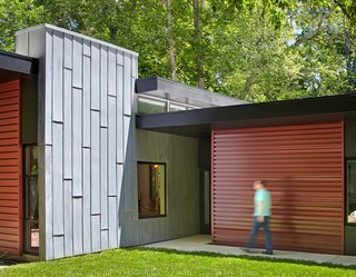 A tall gray wall, made of acid-washed zinc metal, marks the entryway and visually grounds the roof planes. It also separates the living and bedroom volumes.