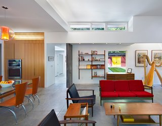 The Aiyyers’ midcentury furniture collection adds personality and color to the open-plan interior. A sofa by Kofod-Larsen for Selig, chairs by Viko Baumritter, shelving by Regner Christensen, and a coffee table by a local craftsmen accentuate the living room, while a dining table and chairs by Calligaris, custom cabinetry with pulls by Mockett, and an overhead Bel Occhio light from Pablo Designs complete the kitchen. Leigh’s harp, from Lyon & Healy, sits nearby.