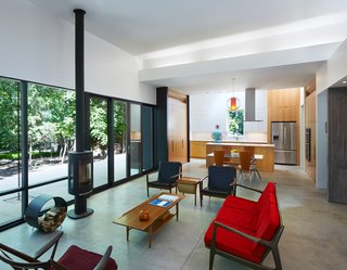 Floor-to-ceiling windows, complemented by a wood-burning stove from Jøtul, bring the outdoors in. "Movement throughout the house—down the hall, through a doorway, or across a room—is always toward a view of the outdoors, creating a connection between the inside and outside," Hart says.
