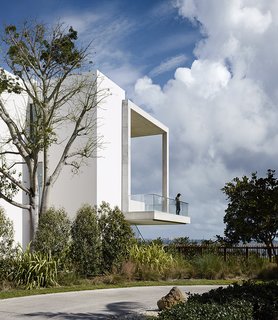 Jutting out over the landscape below, the cantilevered deck at the home of filmmaker-turned-designer Alejandro Landes looks out at Biscayne Bay in Miami's Coconut Grove neighborhood. Designed by Zyscovich Architects, the slim proportions of the porch seem to elude gravity while the subtle texture of the concrete provides a contrast to the smooth surface of the rest of the house.