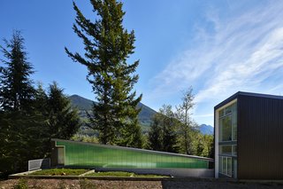 This Retreat in the Cascades is a Bold Take on the Modern Cabin - Photo 4 of 10 - A polycarbonate wall by Lexan Thermoclick colors the west side of the studio. Exterior doors are from Codel, and they are also painted in Benjamin Moore’s "dark pewter."