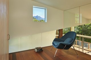 This Retreat in the Cascades is a Bold Take on the Modern Cabin - Photo 8 of 10 - Every room in the home has views to the outdoors, including the loft. Glass walls box in Womb Chairs by Modern Classics.