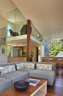 This Retreat in the Cascades is a Bold Take on the Modern Cabin - Photo 7 of 10 - The living room features a "Focus One" couch by Kasala, which sits across from Arper and Catifa 46 dining room chairs by Hive Modern. The pendant lights that hang above them are "Easy" by Kartell.