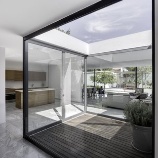 This enclosed patio within one of the modules invites residents to enjoy the outdoors while still protected from the intense heat. The dining room table and chairs designed by Hector Esrawe.