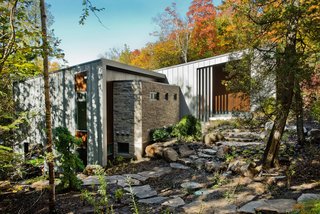 A Tranquil Lakeside Abode in Quebec Unfolds Over Six Levels - Photo 1 of 9 - "The site was beautiful as it is," architect Eric Tremblay said, and he wanted to build a home that had the least impact on the terrain as possible. The lake can be seen on either side of the house, and natural materials—like the Eramosa limestone coating on the exterior—were a priority during construction.