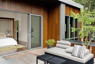 A Tranquil Lakeside Abode in Quebec Unfolds Over Six Levels - Photo 7 of 9 - "The roof terrace accessed from the master bedroom is the sunniest place, naturally," said Tremblay. A custom-made bed by Boom Town, Tremblay’s firm, is outfitted with linens by Kravet. Outdoor seating is by Jardin de Ville.