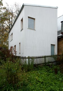 Placed throughout the home’s slatted wood exterior, windows are positioned to allow for the most attractive views and ample natural light. The sloped roof design was chosen for its minimal cost, and for its ability to redirect snow away from a neighboring residence.