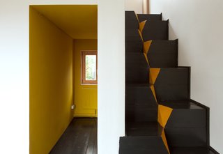 A corridor-like entrance invites residents into the home. The architects chose to use goose-step stairs because of their safety and efficiency in compact spaces. "This staircase is also the easiest in terms of construction," Kolchin says. "It is nearly impossible to make any mistake while building it."