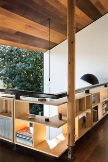 A Home's High Ceilings Are Responsible for Some Impressive Views - Photo 7 of 10 - Simpson runs his practice, WireDog Architecture, from his home study, where custom bookshelves line the perimeter of the mezzanine for a storage solution that doubles as railing.
