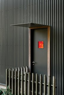 A Home's High Ceilings Are Responsible for Some Impressive Views - Photo 9 of 10 - "I suppose you could consider me part of a subculture who lived in various inner-city spaces," says Simpson, whose previous homes include ad hoc spaces in industrial warehouses, floors of office buildings, and units above shops and bars. In designing his Island Bay home completely from scratch, he retained his experimental spirit: "We wanted a house that responded to our wider social, environmental, and economic concerns rather than something that blindly followed convention," he says. Unassuming in sight, the home’s corrugated-metal cladding (above) recalls the tin shed, a vernacular housing type in the region.