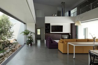 A Home That Dramatically Replicates a Starry Sky in Its Living Room - Photo 7 of 9 - The architect selected a monochromatic scheme to highlight both the courtyard landscaping as well as these sofas by Poltrone e Sofá.