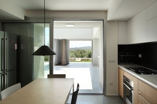 A Home That Dramatically Replicates a Starry Sky in Its Living Room - Photo 8 of 9 - An Artemide Aggregato pendant light hangs over the kitchen table. While most of the home's lighting is intentionally inconspicuous, the architect intened this pendant to stand out.