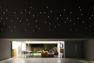 A Home That Dramatically Replicates a Starry Sky in Its Living Room - Photo 3 of 9 - The plexiglass tube's reverse lighting scheme emulates a starry sky above the patio when the interior is lit up at night.