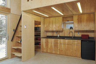 While there are two sleeping lofts—one above the kitchen, the other above the bathroom—the EDGE Cabin's multifunctional furniture can add a third bed.