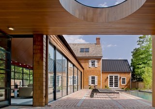"The client wished to more that double the size of the house," Gurney said. "The goal was to provide the additional space as a series of smaller pavilions to allow the original historical house to be the most important part of the composition." Steel swing doors by Hope’s Windows Inc. lead outside, and a custom standing seam metal roof slopes above the far end of the pool.