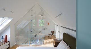 Aside from the master bedroom, there are three additional bedrooms in the house. Gurney and his team used glass throughout to carry light into the home. A Copenhagen nightstand supports a Brazo table lamp in this third-floor guest room.