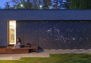 Architect Janna Levitt laser cut an astral pattern into the garage door of this renovated Toronto home, installing LED lights behind the fiber-cement surface to complete her depiction of the constellations Sagittarius and Scorpio.