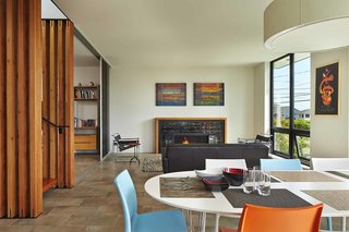 On the first level, the living room and dining room connect to a southeast-facing terrace, which catches the morning and midday sun. A pair of larch sliding doors join the two rooms. Two Marcel Breuer Wassily chairs from Knoll flank the rug, from Room & Board, and Portland Willamette Ovation II fireplace.