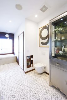 12 Creative Ways to Use Tile in Your Home - Photo 7 of 12 - Replacing the old toilet with a wall-hung Duravit model continues the floating theme, which is echoed by the custom recessed magazine caddy. The room’s sole freestanding piece is a glass-sided cabinet from Restoration Hardware. The diamond-shaped tile is from the Dwell collection at Heath Ceramics.