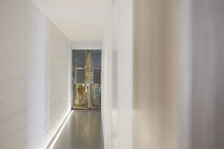 Reclaimed materials, such as this discolored door, play against the sleek modern touches inside. "You can really feel the old shop," says Chabauty. "It’s a great contrast."
