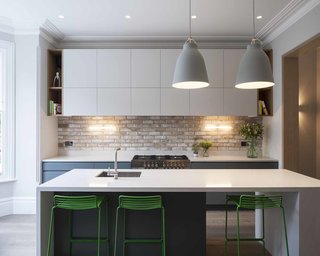 20 Best Modern Kitchen Counters - Photo 8 of 20 - A new kitchen at the front of this London townhouse completes the trifecta of reworked rooms on the main level. It fits nicely into the notion of balancing new and old elements throughout the house, with oak detailing married to exposed brick, offset by strip lamps. The Hee bar stools are by HAY, the Caravaggio P3 pendants are by Light Years, and the range oven is from Britannia.