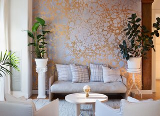 An installation of Wabi River, a silver-and-gold marbled mural by Calico Wallpaper, cofounded by residents Rachel and Nick Cope, forms a palette of coordinated tones in the living area. Nearly all of the furnishings in the apartment are by friends and peers of the local New York design scene: The daybed sofa is by Farrah Sit, the hand-dyed shibori pillows are by Rebecca Atwood, the coffee table is by Fort Standard, and the incense burner is by Apparatus.