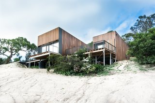 The home, clad in natural Australian timber, enjoys a sense of lightness thanks to slender columns that let it float over the dunes. The driveway and entry, at the rear of the building, have an understated design to build to the interior's magnificent ocean views. Firm director Phil Snowdon explains, "By creating an architectural form that draws your eye and leads you up the steep driveway, we could engage new visitors in a welcoming process that first reveals the object and then slowly reveals the main event, being the view."
