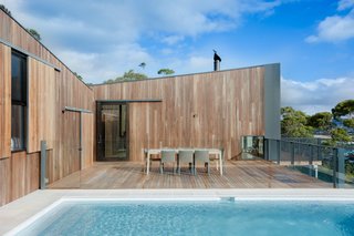 To reduce the home's environmental footprint, OLA installed rain water collection tanks and solar panels, which the house relies upon for water and electricity. White tile and tan travertine pool pavers mimic the color palette of the nearby beach.