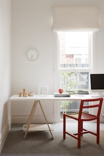 10 Essential Tips For Creating a Hardworking Home Office - Photo 2 of 10 - The study has a fun, playful atmosphere thanks to a red Square Dining Chair from MAP, a Tempo wall clock by Naoto Fukasawa for Magis, and house sculpture from David Band.