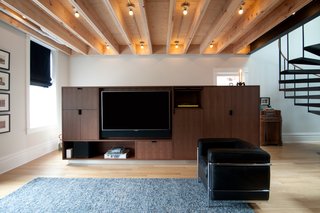 A Chicago Renovation Taps Into its Attic to Almost Double its Square Footage - Photo 4 of 8 - One of Shively's top priorities was an innovative lighting scheme that would combat the dark interiors that many narrow Chicago homes create. Thanks to centrally located skylights and rows of bulbs between wood beams, the house enjoys an even glow and details like this Le Corbusier chair aren't obscured.