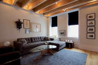 A Chicago Renovation Taps Into its Attic to Almost Double its Square Footage - Photo 5 of 8 - "It was a design priority that any modern interventions had an articulate edge or gap against the existing space," says Shively. As a result, he designed a subtle gap between the exposed beam ceiling and the existing walls. The living room also features a Gus* Modern sofa and Adrian Pearsall coffee table.