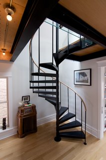 A Chicago Renovation Taps Into its Attic to Almost Double its Square Footage - Photo 6 of 8 - Shively had a carpenter from TomKal Construction build a custom handrail, out of white oak to match his floors, for this spiral staircase.