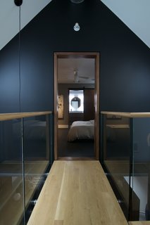 A Chicago Renovation Taps Into its Attic to Almost Double its Square Footage - Photo 7 of 8 - Though hard to spot, another gap separates the new attic catwalk—which runs between the guest and master bedrooms—from the old walls. As with the living room ceiling, says Shively, "I wanted the new parts to float and have a sense of movement in the space." A steel structure underneath the walkway does, however, connect to the walls. The white oak floors also help the new attic level blend with the rest of the house.
