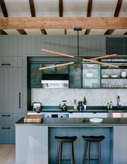 A Passive House and "Sauna Tower" Join a 19th-Century Barn in the Hudson Valley - Photo 5 of 13 - A custom Stickbulb LED lamp hangs above a kitchen island topped by concrete from Get Real Surfaces. The beams are stained with LifeTime from Valhalla Wood Preservatives, which will oxidize the material over time.