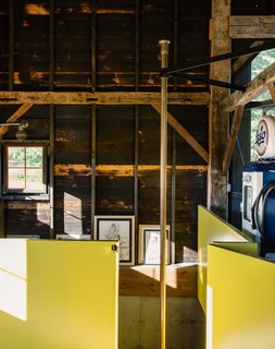 A Passive House and "Sauna Tower" Join a 19th-Century Barn in the Hudson Valley - Photo 9 of 13 - The contractor sourced the brass pole from a fire station in Boston. The surrounding wall is painted in semi-gloss paint in Citrus by Sherwin Williams, a sunny hue the team playfully referred to as Dwell-ow.