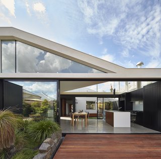 15 Modern Additions to Traditional Homes - Photo 5 of 15 - "From the beginning we knew we needed to remove the rear 80s extension and preserve the front Edwardian home," architect Michael Ong says. "So, we were interested in how the two different architectural styles would work together." The old Edwardian home can be seen in the center of the frame, through the dining room and kitchen of the addition. Merbau Decking extends into the garden, which became the focal point of the home.