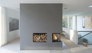 Scandinavian architecture firm C.F. Møller designed a serene, zinc-clad home in Aarhus, Denmark. On the interior, a large, three-sided fireplace incorporated into a floating wall helps connect two spaces and warm up the home.