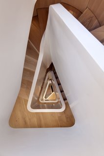 FORMstudio designed an acrylic balustrade that winds up the 1,647-square-foot home's five levels. The flooring throughout is white oak. The staircase is about 46 feet tall from top to bottom. 