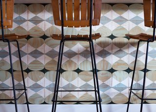 In the kitchen, the couple have applied a series of square plywood tiles by Moonish at the bar counter. Forming a graphic, mosaic-like effect, the geometric designs can be mounted magnetically, in an easy-to-install system that invites reconfiguration and play—for adults and kids alike.