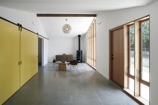 The renovated stable's living room is extra bright thanks to walls painted with Benjamin Moore’s Atrium White and reflective polished concrete floors. The latter conceal a radiant heating system.